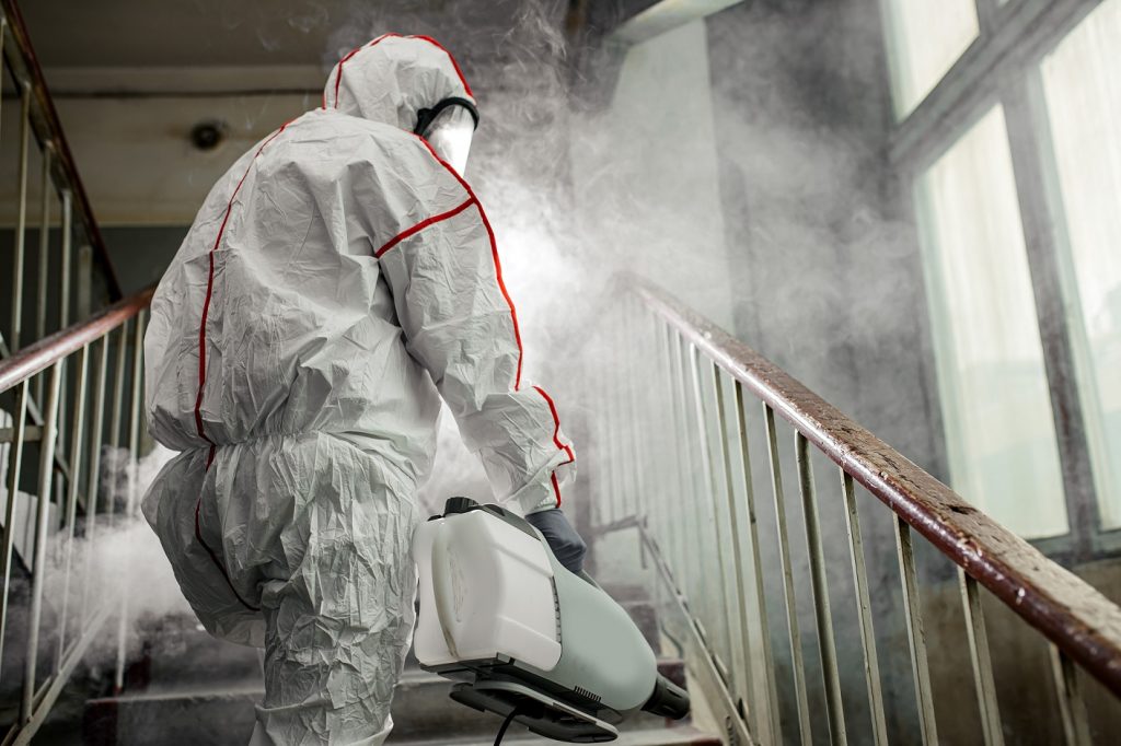 Man in a protective suit for disinfection