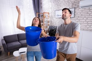 Young couple collecting water in the house