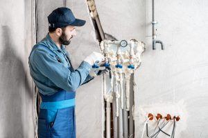 Workman installing water heating system