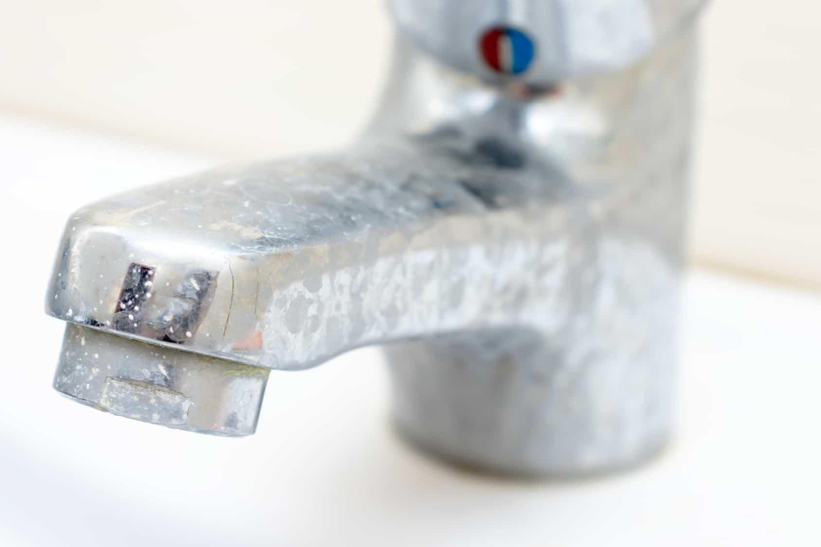 Scale buildup on a faucet caused by hard water.