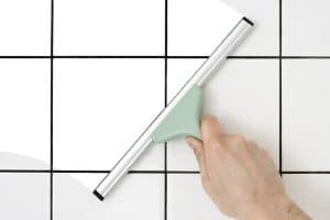 mold removal and prevention by using a squeegee on bathroom tile walls