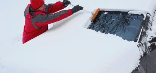 Man removing snow off of car