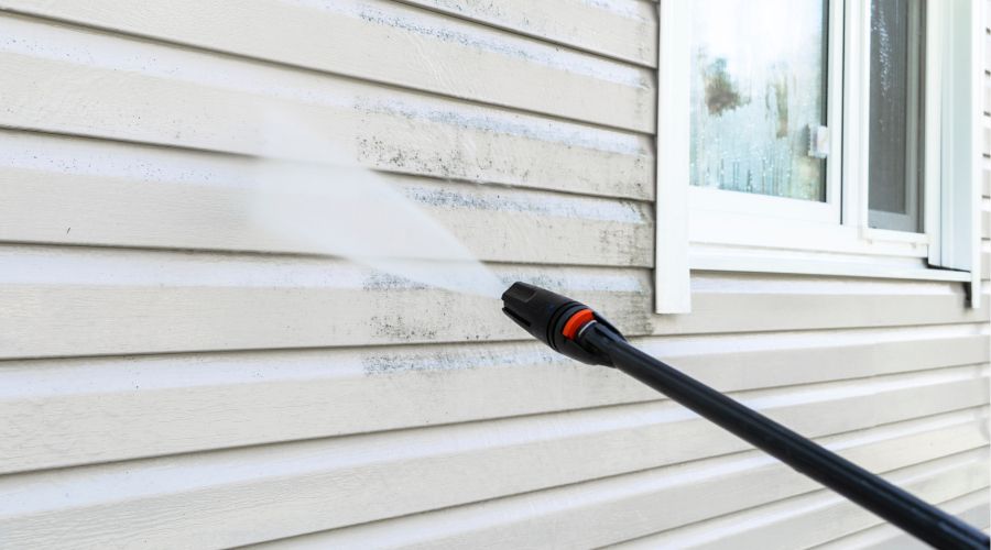 A professional restoration technician cleaning soot from walls after fire damage