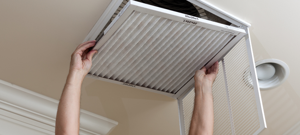 Senior Man Opening Air Conditioning Filter in Ceiling